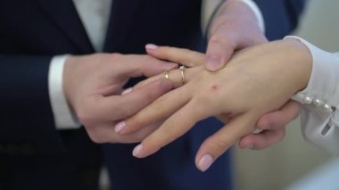 Gelin ve damat törende alyanslarını değiş tokuş ederler. Hoş bir çift.
