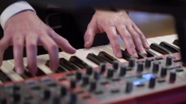 Elektronik klavye sentezleyici piyano çalan müzisyen. Konser sahnesinde müzik çalan bir grup.