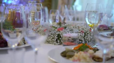 Bardaklar, tabaklar, çatal bıçak ve peçeteler. Parti için çiçeklerle süslenmiş masalar. Düğün resepsiyonu, doğum günü, yıldönümü.