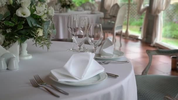 Gläser, Teller, Besteck und Servietten. Geschmückte Tische mit Blumen für die Party. Hochzeitsempfang, Geburtstag, Jubiläum. — Stockvideo