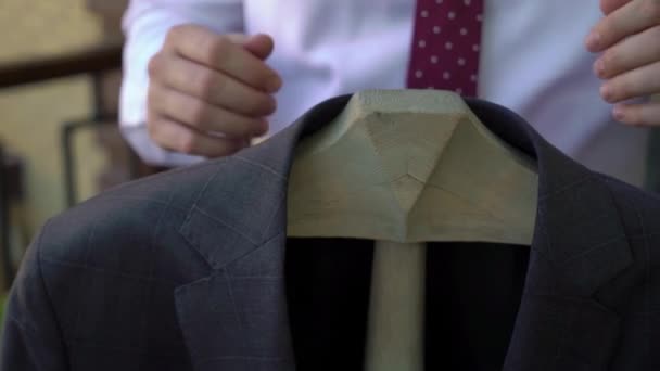 Young man put on jacket. Dressing for celebration event, business meeting or wedding — Stock Video