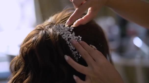 Перукар виконує зачіску наречених. Весільна зачіска для молодої дівчини. Стиліст робить укладання волосся — стокове відео