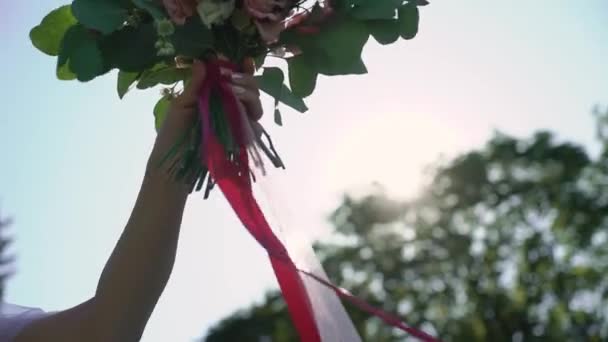 Mladá nevěsta ve svatebních šatech drží kytice květiny v parku. Bílé luxusní šaty móda — Stock video