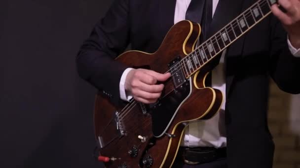 Gitarist speelt gitaar bij concert. Muzikant met strijkinstrument op het podium. — Stockvideo