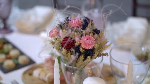 Vasos, platos, cubiertos y servilletas. Mesas decoradas con flores para la fiesta. Recepción de la boda, cumpleaños, aniversario. — Vídeos de Stock