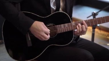 Gitarist konserde gitar çalıyor. Sahnede telli enstrümanlı müzisyen.