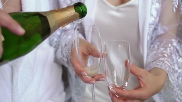 Genç çift şampanya şişesini açıp bardakları dolduruyor. Alkol ve içecek.. — Stok video