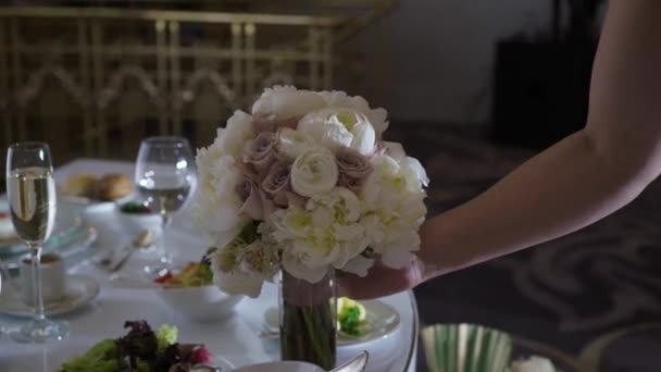 Bruden tar blomster bukett på bryllupsfesten. – stockvideo