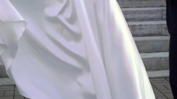 Giovane sposa in abito da sposa agitando e gettando la coda in una città. Bianco moda abito di lusso — Video Stock