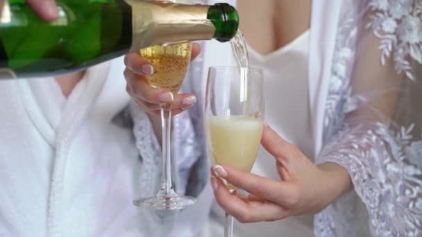 Junges Paar öffnet Flasche Champagner und gießt Gläser zu Hause ein. Alkohol und Getränke. — Stockvideo