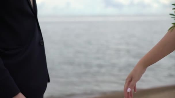 Plajda evlenen çift. Gelin ve damat el ele tutuşuyorlar. — Stok video