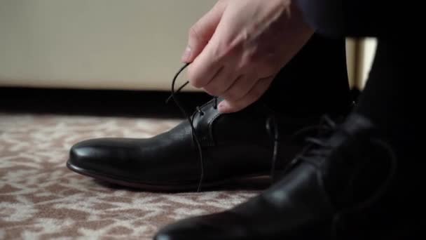 Junger Mann zog Schuhe an. Dressing für Feierlichkeiten, Geschäftstreffen oder Hochzeiten — Stockvideo