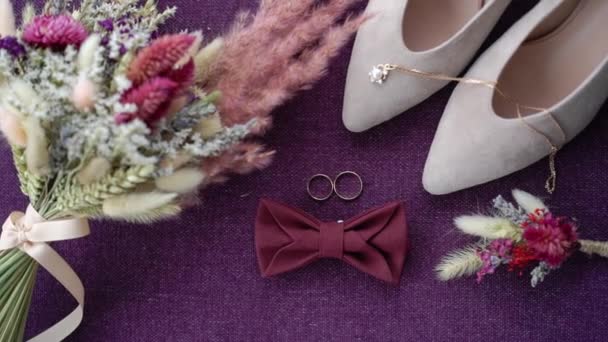 Jegygyűrűk, virágcsokrok és menyasszonyi cipők. Házassági szimbólumok. A menyasszony és a vőlegény szeretete feleség és férj lesz. Házassági szimbólum. — Stock videók