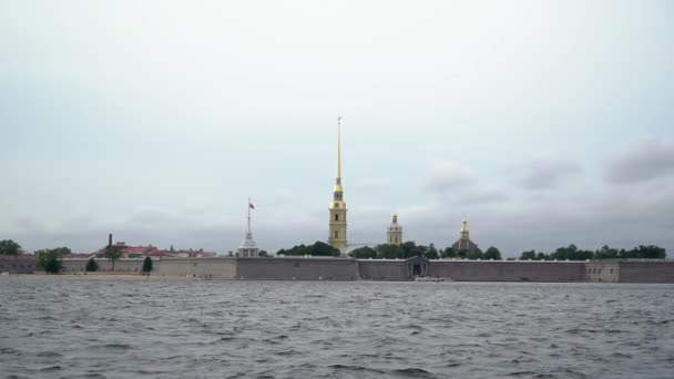 Statek pasażerski z turystami w kanale rzeki miasta. Widok na rzekę Neva, most pałacowy i twierdza Piotra i Pawła — Wideo stockowe