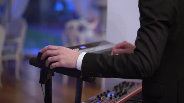 Pemain musik memainkan piano synthesizer keyboard elektronik. Band di panggung konser bermain musik — Stok Video
