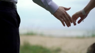 Plajda evlenen çift. Gelin ve damat el ele tutuşuyorlar.