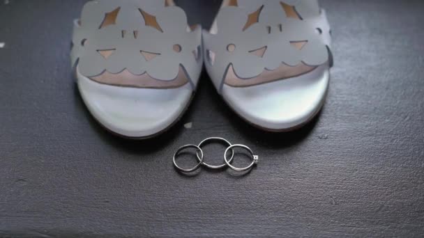 Обручальные кольца и свадебные туфли. Пара брачных символов. Любовь невесты и жениха, ставших женой и мужем. Символ брака. — стоковое видео
