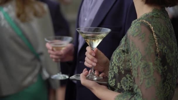 Особа, яка тримає келих вина або шампанського або інший алкогольний напій в руці на вечірці . — стокове відео