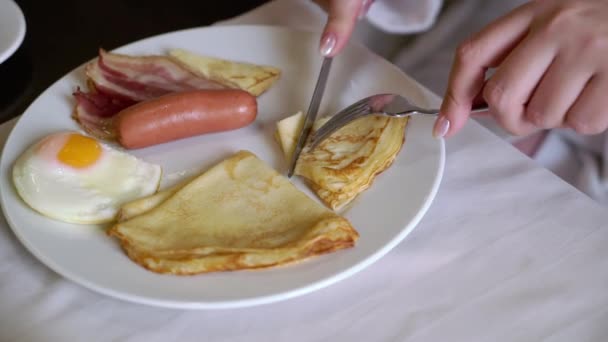 Žena, která ráno snídá. Talíř se smaženými vejci, palačinkou a klobásou. — Stock video