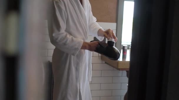 Facet czyści i poleruje buty śmietaną. Mężczyzna w szlafroku rano. — Wideo stockowe
