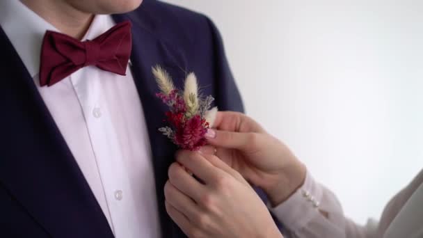 Bride put on boutonniere for groom. Wedding ceremony preparation — Stock Video