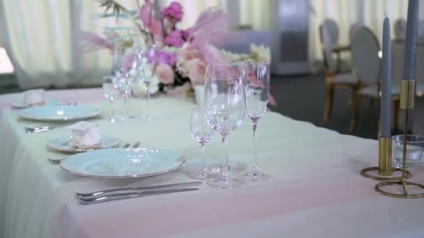 Очки, тарелки, столовые приборы и салфетки. Украшенные столы с цветами для вечеринки. Свадебный прием, день рождения, юбилей. — стоковое видео