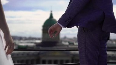Gelin ve damat şehirde yürüyor. Genç ve güzel bir çift. Gelin çiçekleri buketi