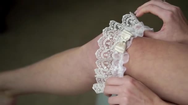 Junge Braut zog Strumpfband am Bein an. Hochzeit. — Stockvideo