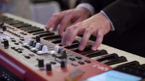 Músico tocando el piano sintetizador de teclado electrónico. Banda en el escenario de concierto tocando música — Vídeos de Stock