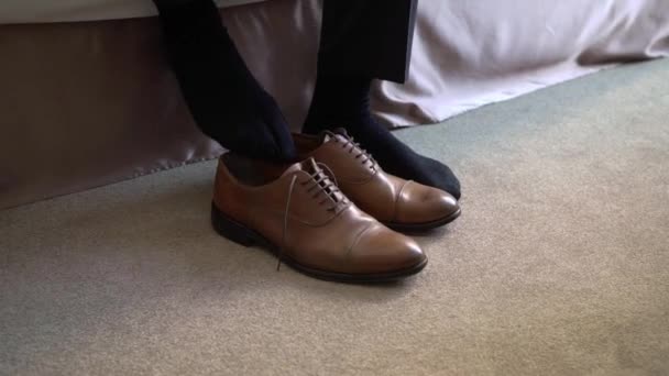 Mladý muž si obul boty. Šaty na oslavu, obchodní jednání nebo svatbu — Stock video