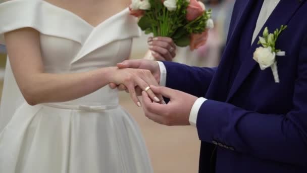 Bride and groom exchange wedding rings at ceremony. Lovely couple — Stock Video