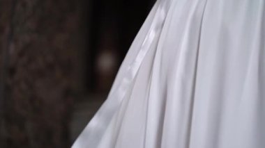 Gelinlik içinde bir şehirde çiçek tutan genç bir gelin. Beyaz lüks elbise modası