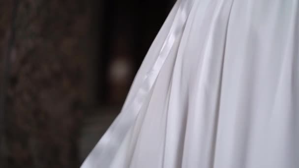 결혼 예복을 입은 젊은 신부 가 도시에서 꽃다발을 들고 있다. 흰색 고급 가운 유행 — 비디오