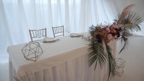 Okulary, talerze, sztućce i serwetki. Ozdobione stoły z kwiatami na imprezę. Wesele, urodziny, rocznica. — Wideo stockowe