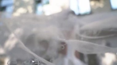 Yazın bir şehir caddesinde yürüyen güzel genç bir gelin. Rüzgarda sallanan peçe