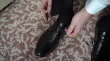 Genç adam ayakkabı giydi. Kutlama, iş toplantısı ya da düğün için giyinme