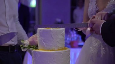 Düğün pastası. Partide geleneksel kutlama tatlısı. Gelin ve damat bir parça kesti.
