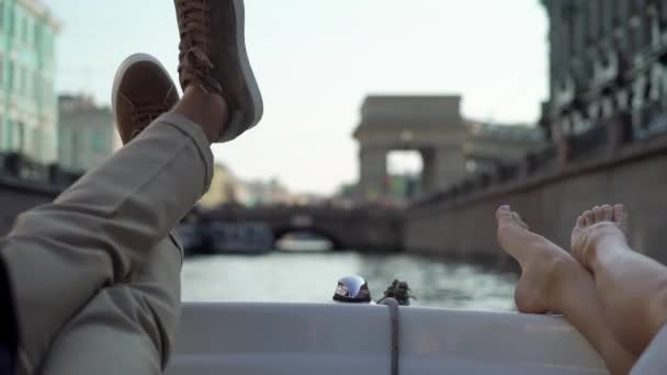Молодая пара плавает на лодке или яхте в городе. Ноги босиком. Поездка жениха и невесты в день свадьбы — стоковое видео