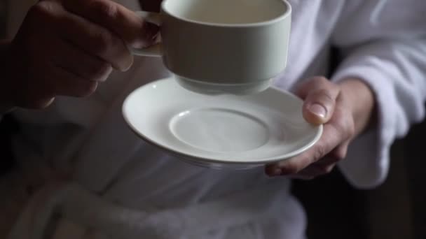 朝、若い男がカップからお茶を飲む。家での朝食 — ストック動画