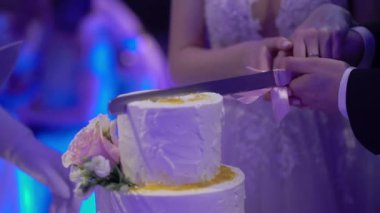 Düğün pastası. Partide geleneksel kutlama tatlısı. Gelin ve damat bir parça kesti.