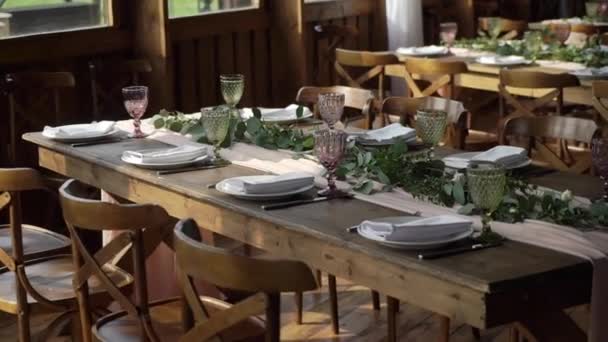 Glasögon, tallrikar, Bestick och servetter. Dekorerade bord med blommor för festen. Bröllopsmottagning, födelsedag, årsdag. — Stockvideo