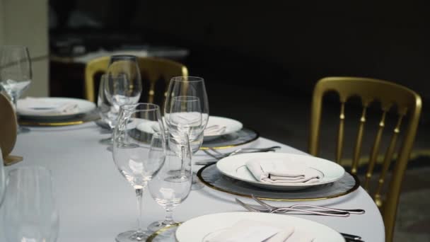 Vasos, platos, cubiertos y servilletas. Mesas decoradas con flores para la fiesta. Recepción de la boda, cumpleaños, aniversario. — Vídeo de stock