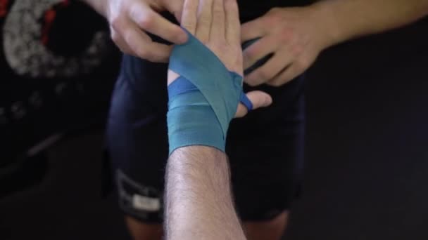 Man put on blue straps on wrist before fighting. Wearing and preparing before boxing — Stock Video