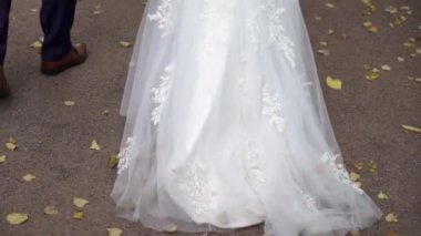 Genç bir çift parkta yürüyor. Gelin ve damat yazın