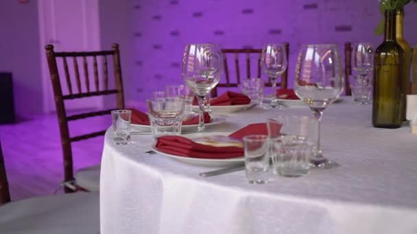 Glasses, plates, Cutlery and napkins. Decorated tables with flowers for the party. Wedding reception, birthday, anniversary. — Stock Video