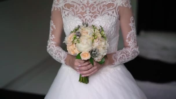 Mladá nevěsta ve svatebních šatech drží kytice květiny uvnitř. Bílé luxusní šaty móda — Stock video