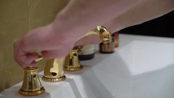 Человек, использующий умывальник утром, чтобы брызгать водой в лицо и мыть руки — стоковое видео