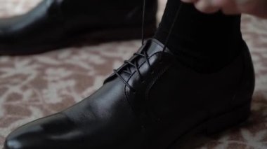 Genç adam ayakkabı giydi. Kutlama, iş toplantısı ya da düğün için giyinme