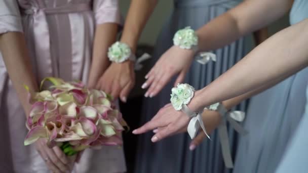 Noiva e damas de honra posando no dia do casamento. Meninas mãos com flores pulseiras e esposa com buquê de noiva — Vídeo de Stock