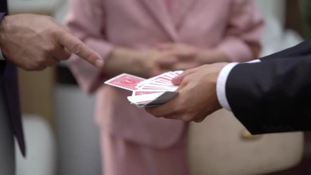 Magiker man visar street magic trick med kort. — Stockvideo